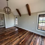 An empty room with wood floors and a window.