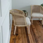 Two chairs in a room with hardwood floors.
