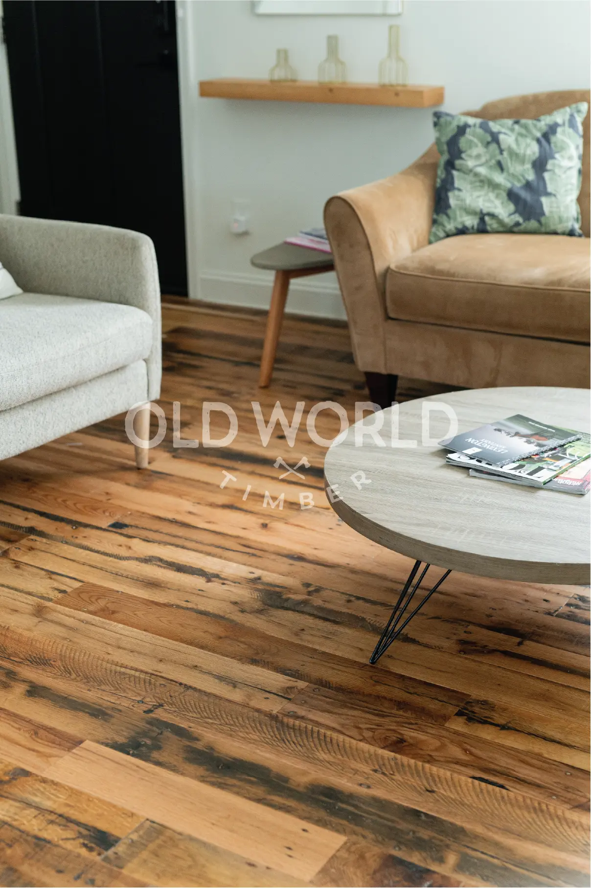 Historic industrial oak floor with visible nail holes and aged textures installed in a warm living area with mid-century modern furniture.