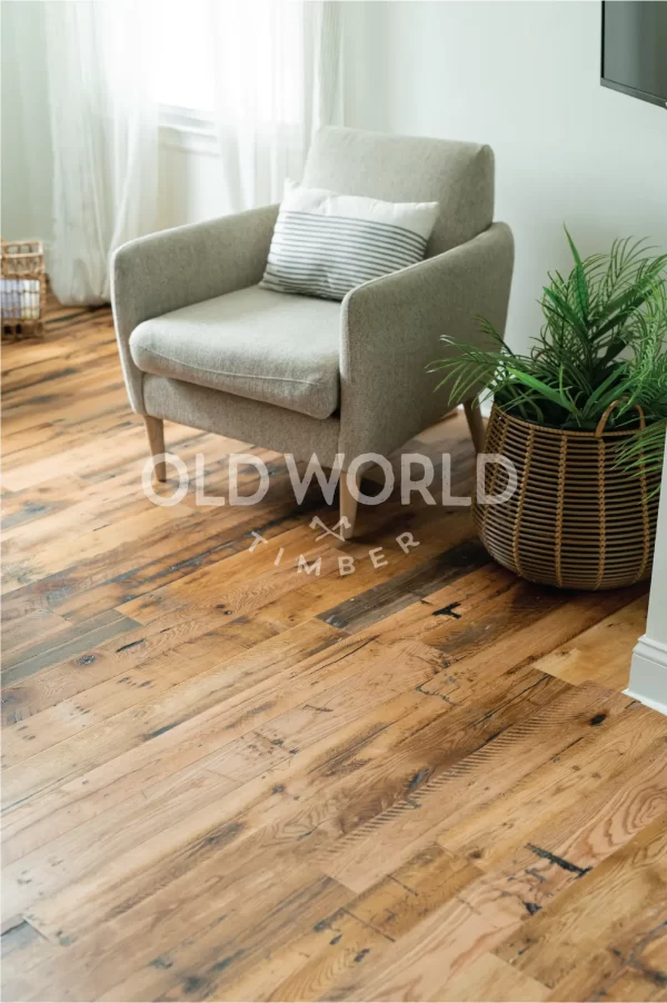 Industrial Oak engineered hardwood flooring paired with a cozy gray lounge chair and woven basket planter in a bright living space.