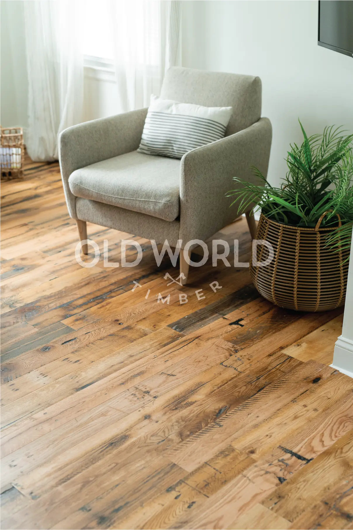 Industrial Oak engineered hardwood flooring paired with a cozy gray lounge chair and woven basket planter in a bright living space.