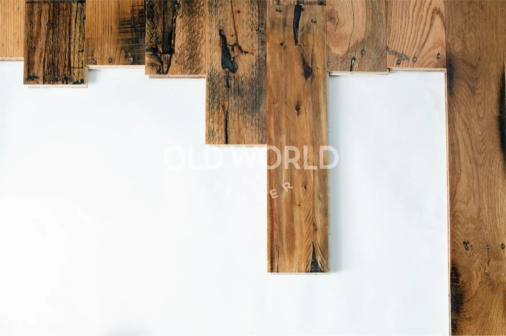 Top-down view of reclaimed Industrial Oak flooring planks showing distressed grain, dark streaks, and saw marks.
