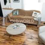 Full room view of engineered reclaimed oak floors with a rustic-modern blend of furniture, showcasing warmth and industrial charm.