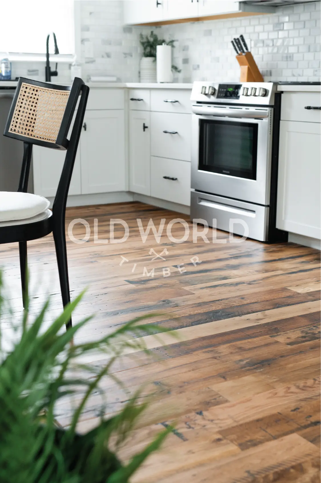 Close-up of Industrial Oak Engineered Flooring reclaimed from antique factories, installed in a white kitchen with stainless steel appliances.