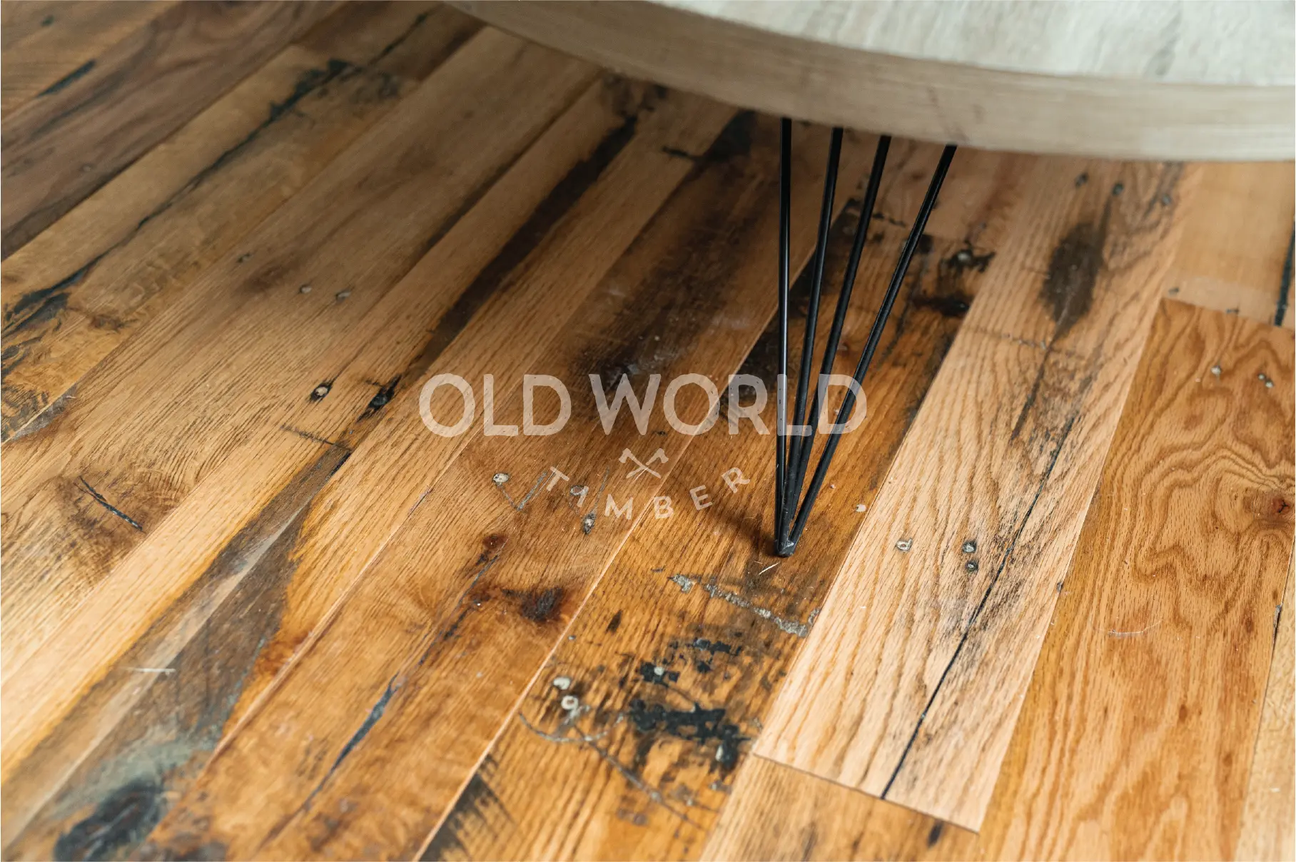 Authentic reclaimed oak flooring planks showing original saw marks and bolt holes, emphasizing industrial heritage.