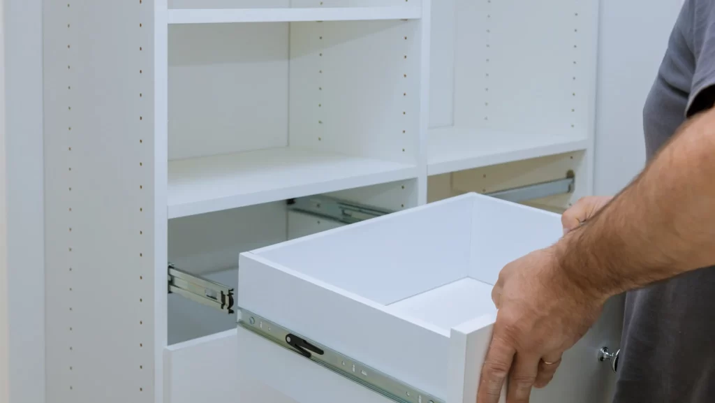 A man removing cabinet drawer