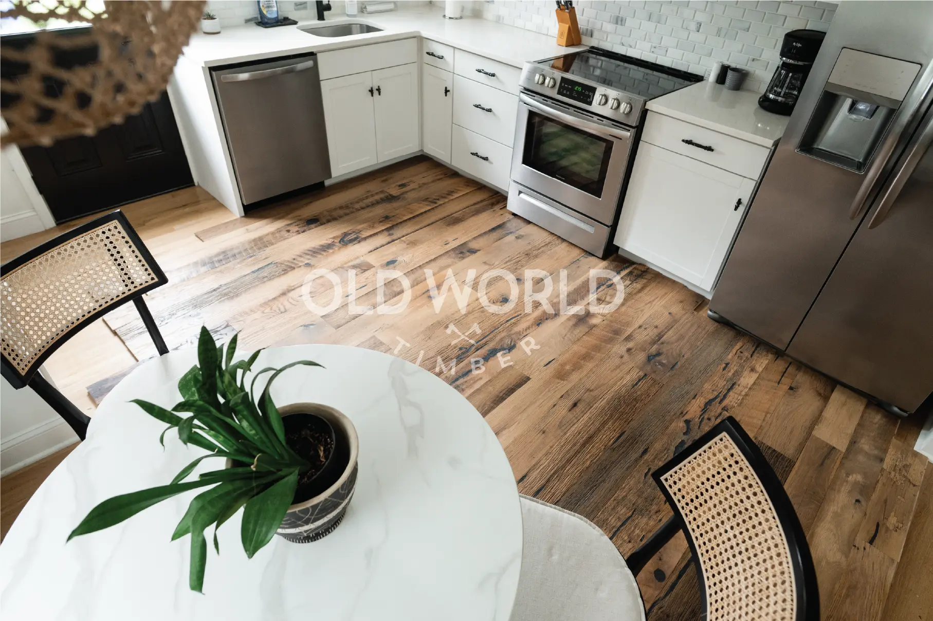 Wide kitchen view showing full layout of reclaimed Heartland Barnwood Mixed Oak engineered flooring and white shaker cabinets.