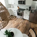 Heartland Barnwood Mixed Oak reclaimed engineered flooring in a naturally lit kitchen with stainless steel appliances and dining table.