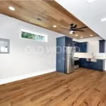 Wide view of a modern kitchen and dining space featuring Modern Harvest engineered oak flooring with smooth tones and subtle rustic details.