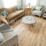 Cozy seating area with soft furnishings and engineered reclaimed oak flooring, showing subtle nail holes and saw kerfs from its industrial past.