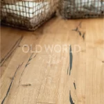 Natural oak engineered planks with distinctive dark markings and sustainable craftsmanship, shown beneath woven storage baskets.