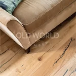 Detail of Modern Harvest oak flooring beneath a beige sofa, showing eco-conscious craftsmanship and salvaged wood inspiration.
