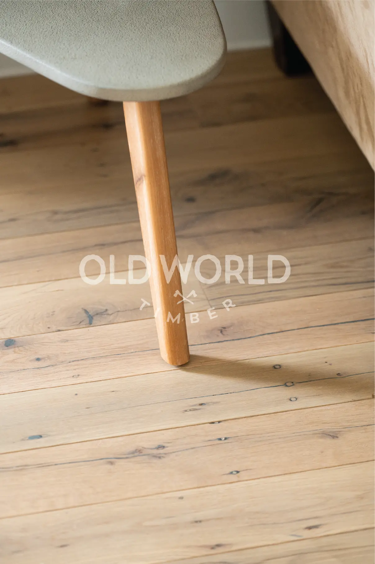 Industrial oak clean face engineered wood flooring with soft character marks under a rounded wooden table leg in a modern home.