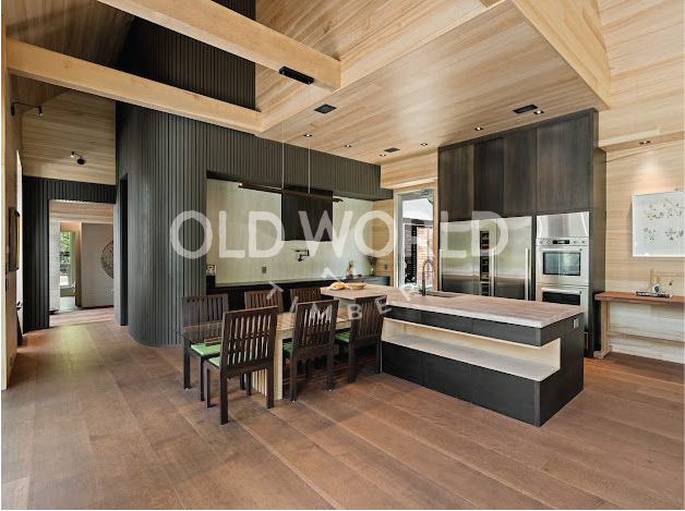 Rift and quartered oak engineered flooring in a modern kitchen and dining space with architectural lighting and exposed beams.