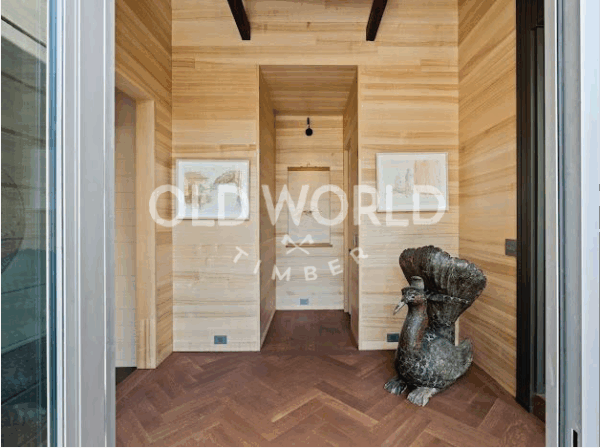 Oak Rift and Quartered wood flooring in a contemporary entryway with natural wood paneling and decorative sculpture.