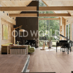 Wide-plank rift and quartered oak flooring in a bright living room with floor-to-ceiling windows and exposed wood beams.