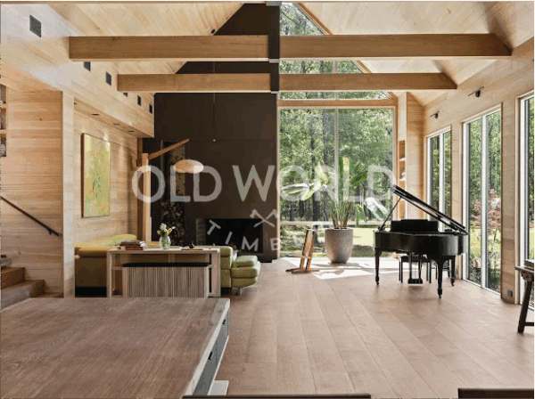 Wide-plank rift and quartered oak flooring in a bright living room with floor-to-ceiling windows and exposed wood beams.